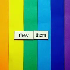 Fondo arcoíris con tarjetas que dicen "they" y "them", representando pronombres personales en inglés.