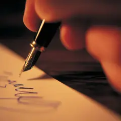 Mano escribiendo una carta informal con pluma fuente.