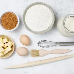Ingredientes para hornear: harina, azúcar, mantequilla, huevos, leche, batidor, brocha y rodillo.