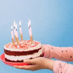 Pastel de cumpleaños con velas encendidas, listo para decir "feliz cumpleaños en ingles".