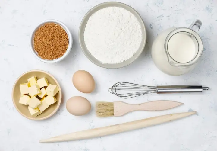 Ingredientes para hornear: harina, azúcar, mantequilla, huevos, leche, batidor, brocha y rodillo.