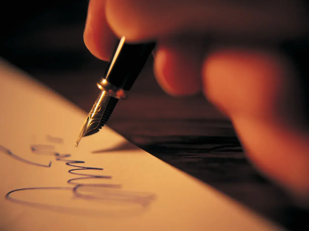 Mano escribiendo una carta informal con pluma fuente.