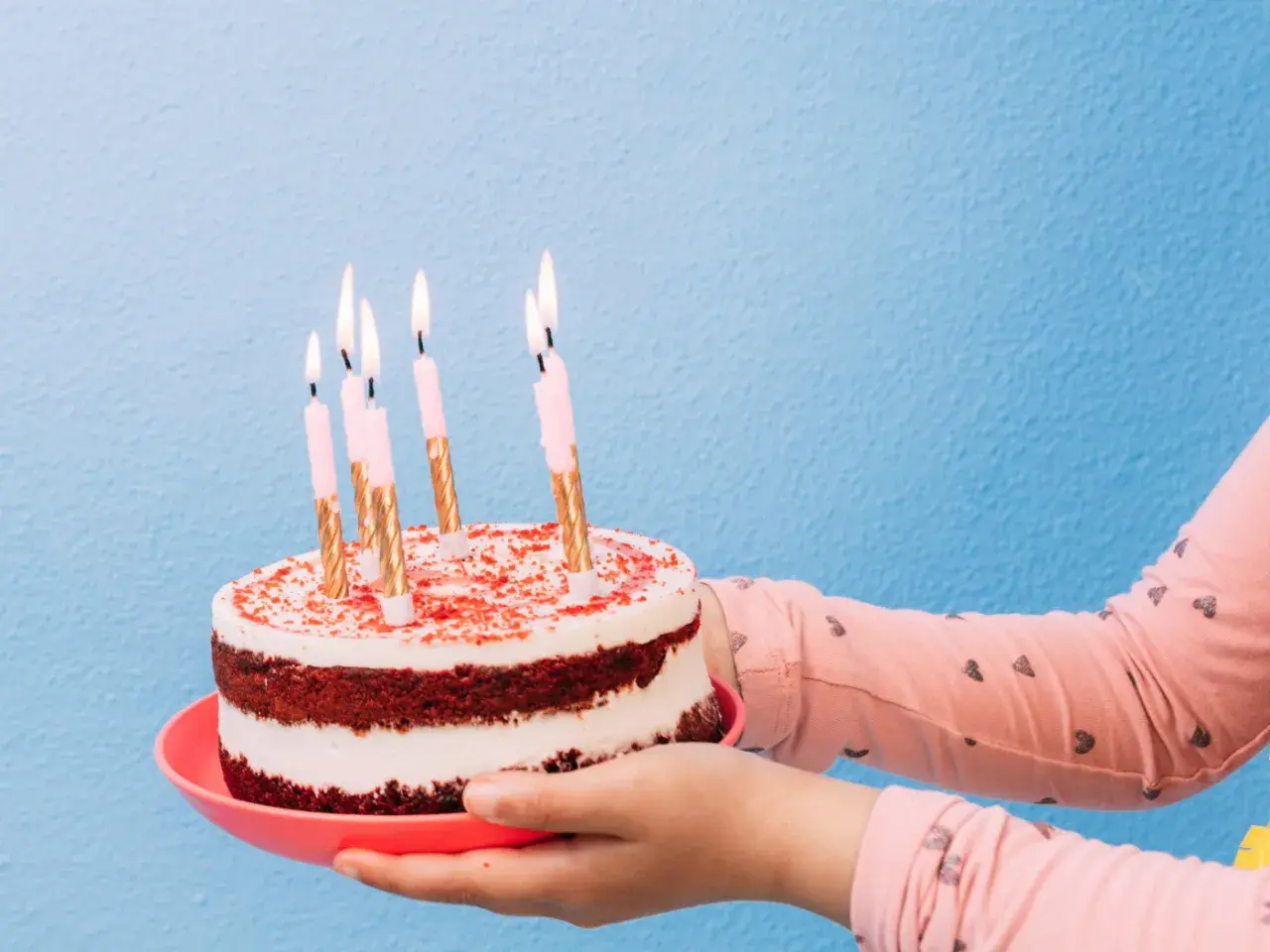 Pastel de cumpleaños con velas encendidas, listo para decir "feliz cumpleaños en ingles".